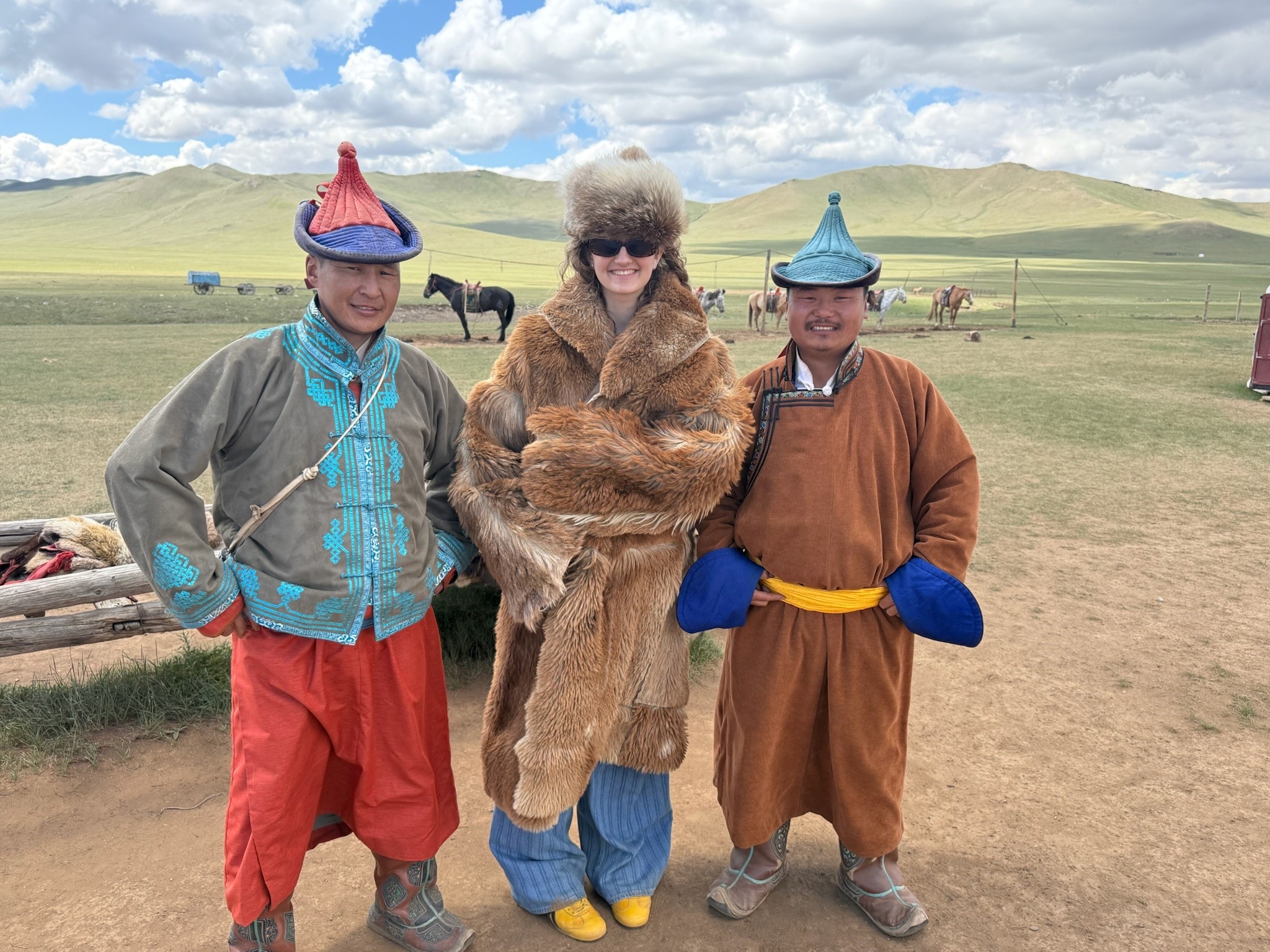 Woman in fur coat with Mongolian locals on the steppe